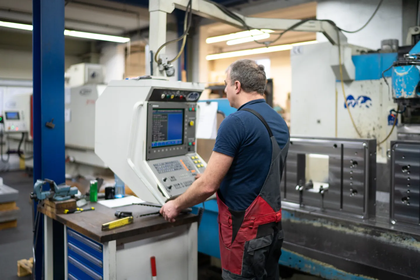 MAWI-Mitarbeiter an der Steuerung einer CNC-Maschine